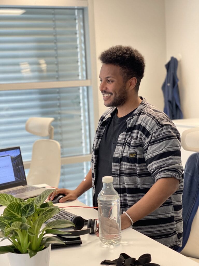 Picture of a smiling man working at his computer