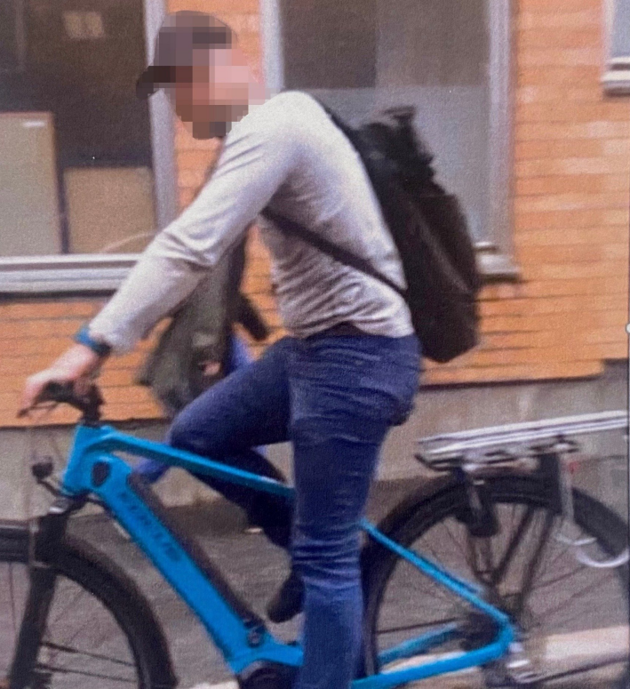 Thief with blurred face cycling away on his stolen bike
