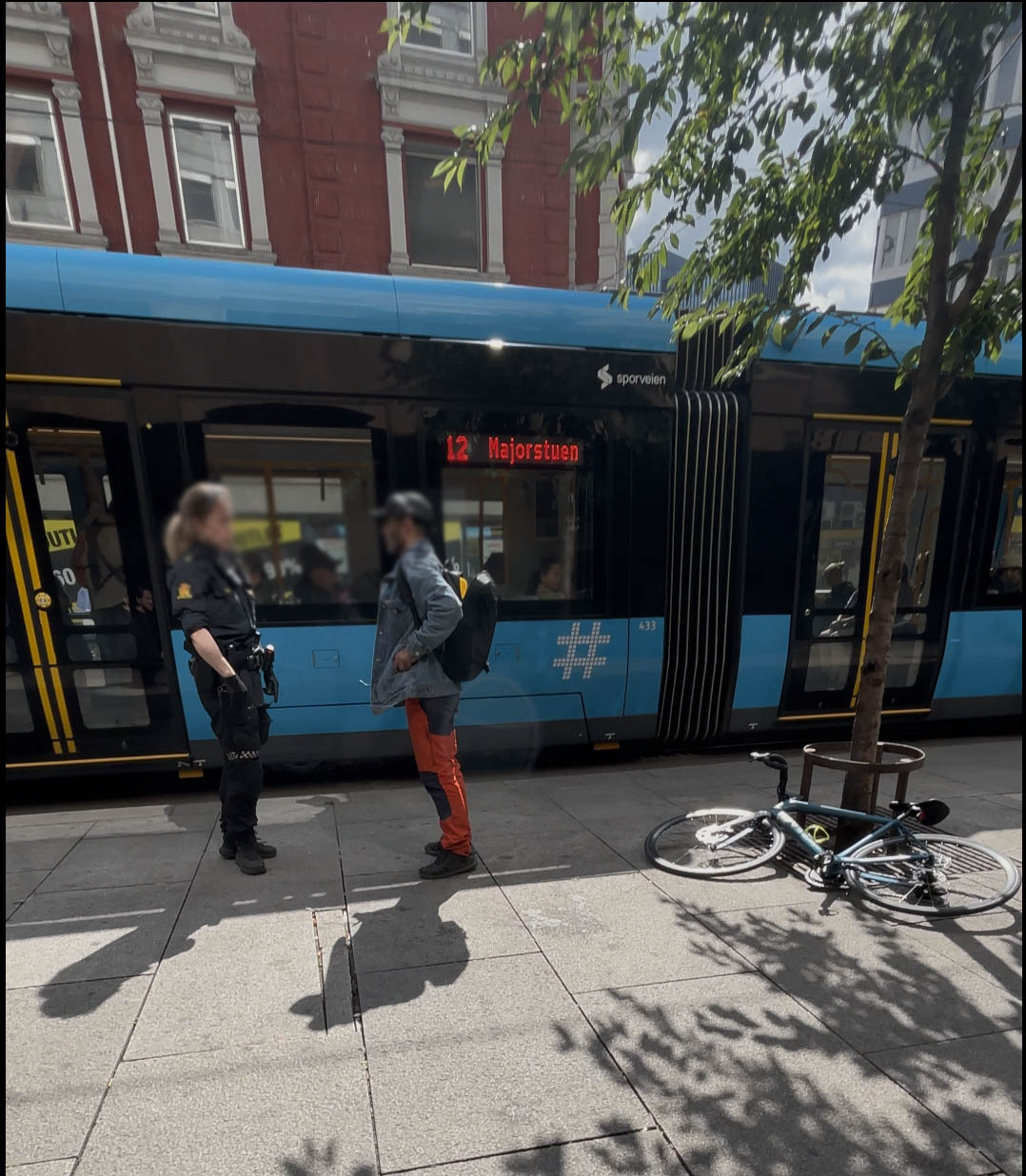 Oslo Police confronting bicycle thief with Majorstuen tram behind. BikeFinder tracker hidden inside the bike laying on the ground.