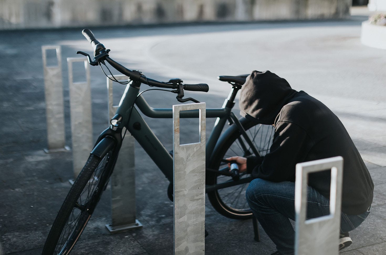Bike theft in progress — thief cutting lock at bike rack