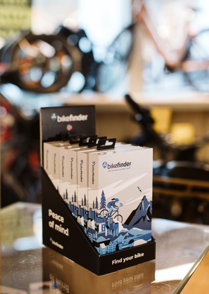 BikeFinder retail display stand with packaged bike trackers in a bicycle shop – dealer and retailer sales solution.